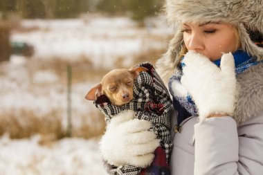 Genç bir kadın soğuk kış gününde en iyi arkadaşını sıcak battaniye eşarbına sardı. Hayvan koruma programı. Evlat edinme kavramı