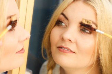 Makyaj yapan, kirpiklerini fırçalayan, kirpiklerini fırçalayan kadınların yakın çekim görüntüleri..