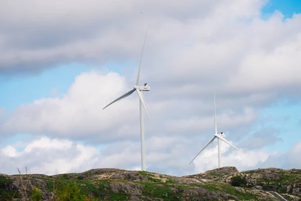 Power generators farm on rocky coast hills, wind turbines in Norway. Renewable eco energy concept.