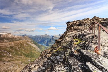 Dalsnbba bölgesinden Geirangerfjord ile panoramik dağlar manzarası. Geiranger Skywalk dağdaki platformu uzaktan görüyor. Norveç.