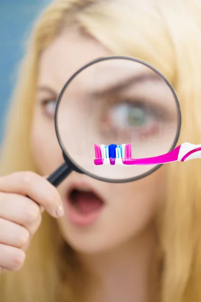 美しい完璧主義者若い女性 Manifying ルーペ ガラスを通して彼女の歯ブラシをチェックします 不稔性の概念 — ストック写真