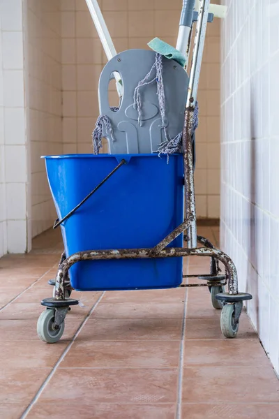 Trolley with bucket full of water and mop. Household or industrial cleaning objects.