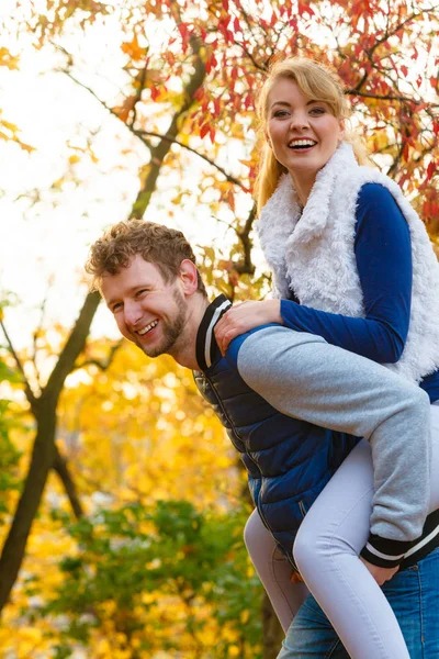 爱约会概念与健康的关系 情侣夫妻有乐趣 给人依附在秋天公园的女人 年轻的成年人的女朋友和男朋友拥抱快乐 — 图库照片
