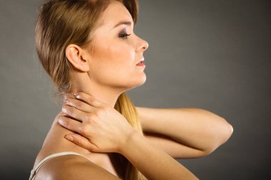 Yorgunluktan sırtım ve omurga hastalığım var. Kadının çok kötü ağrısı var. Kadın ellerini boynuna koyup acıdan kıvranıyor.