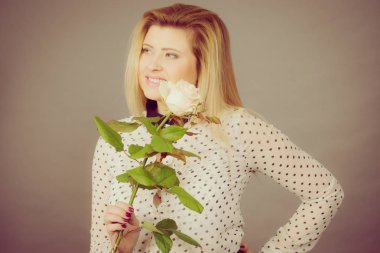 Beyaz gül tutan mutlu pozitif kadın. Sevgililer ve kadının gün hediye fikirleri kavramı.