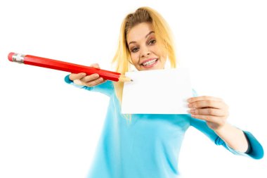 Genç bir kadın büyük boy kalem kullanarak kağıt parçasına notlar yazıyor..