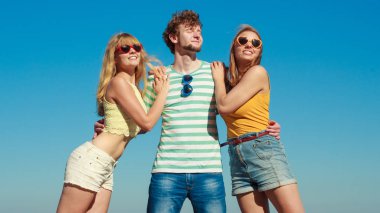 Dostluk mutluluk yaz tatil kavramı. Arkadaşlar çocuk iki kız eğleniyor açık gökyüzü karşı güneş gözlüğü grubu