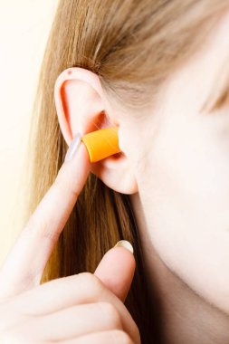 Yüksek sesle yerinde gürültü kurtulmak onun kulaklarına kadın koyarak kulak tıkacı.