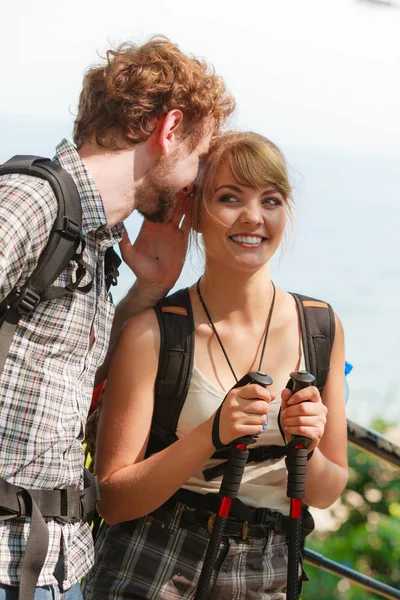 つの若者が屋外ハイキング観光客 バックパッカーは 夏の休暇旅行の旅行をカップルします 男が女の耳にささやく — ストック写真
