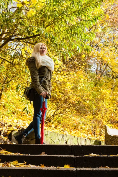 Vrouw staande op de trap in de herfst park — Stockfoto