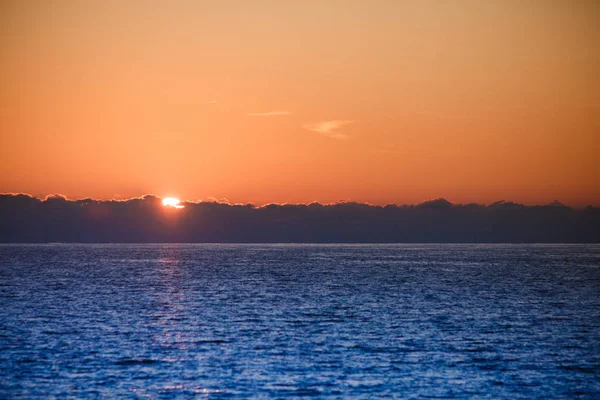 Nascer do sol ou pôr do sol sobre a superfície do mar — Fotografia de Stock