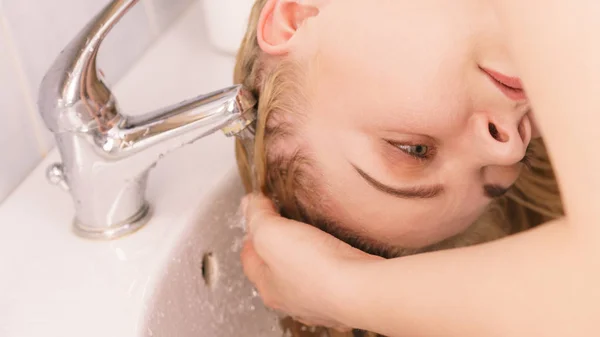 Frau wäscht Haare im Waschbecken des Badezimmers — Stockfoto