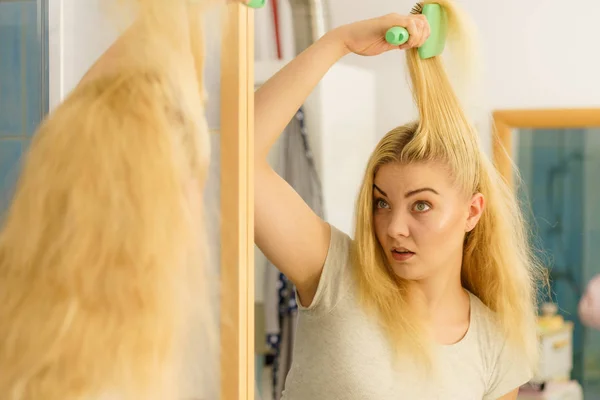Грустная женщина расчесывает волосы — стоковое фото
