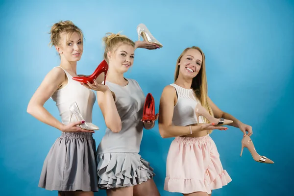 Tři ženy, které ukazují vysoké podpatky obuvi — Stock fotografie