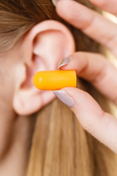 Mulher colocando tampões de ouvido — Fotografia de Stock