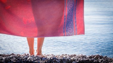 Kadın plajda havlu ile kalça kapsayan