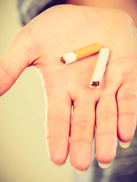 Detailní záběr rozbité cigarety na mužské ruce. — Stock fotografie