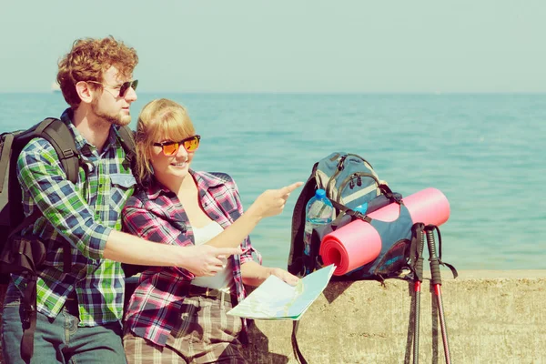 Pareja mochilero con mapa por playa — Foto de Stock