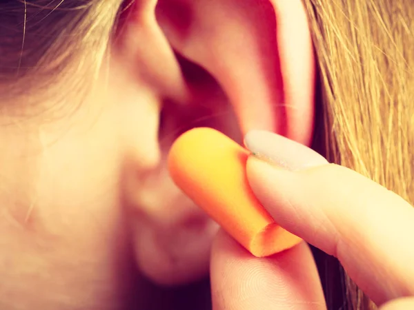 Femme mettant bouchons d'oreilles — Photo