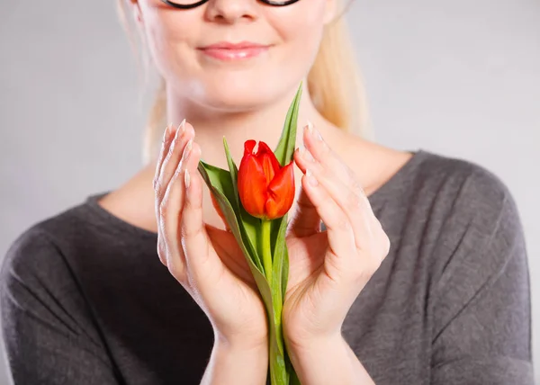 Leende kvinna omfamnande blomma. — Stockfoto