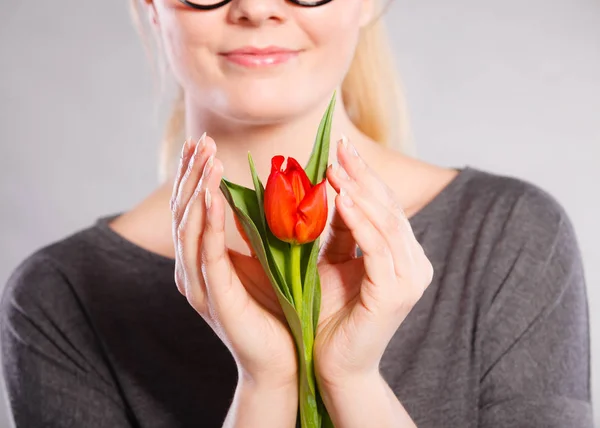 Lächelnde Frau umarmt Blume. — Stockfoto