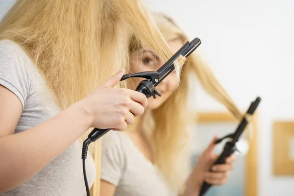 Femme utilisant boucleur de cheveux — Photo