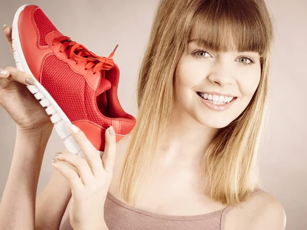 Glückliche Frau präsentiert Sportbekleidung Turnschuhe — Stockfoto