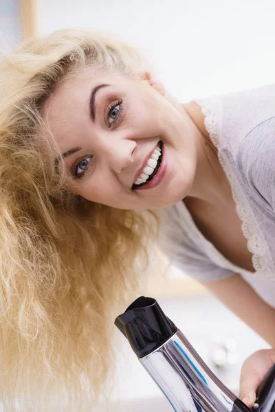 Mulher loira usando secador de cabelo — Fotografia de Stock