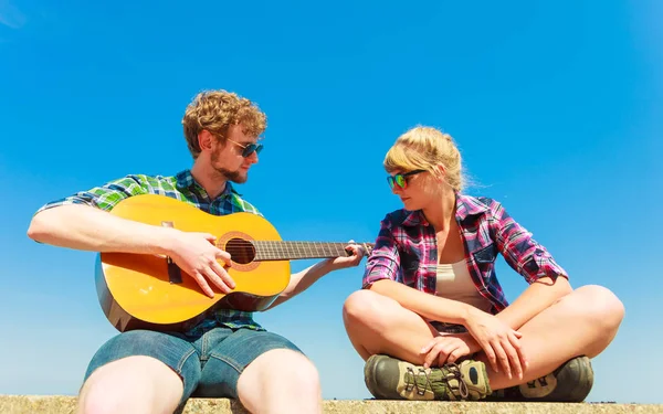 Joven tocando la guitarra a su novia al aire libre — Foto de Stock