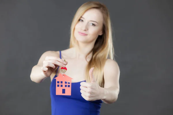 Mujer sosteniendo la llave con símbolo de la casa — Foto de Stock