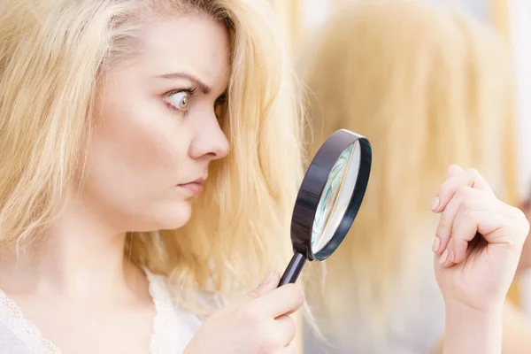 Жінка збільшуючи її роздвоєні кінці волосся — стокове фото