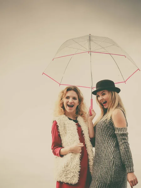 Twee modieuze vrouwen en parasol — Stockfoto
