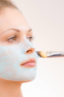 Kız yüz yeşil çamur maskesi uygulamak