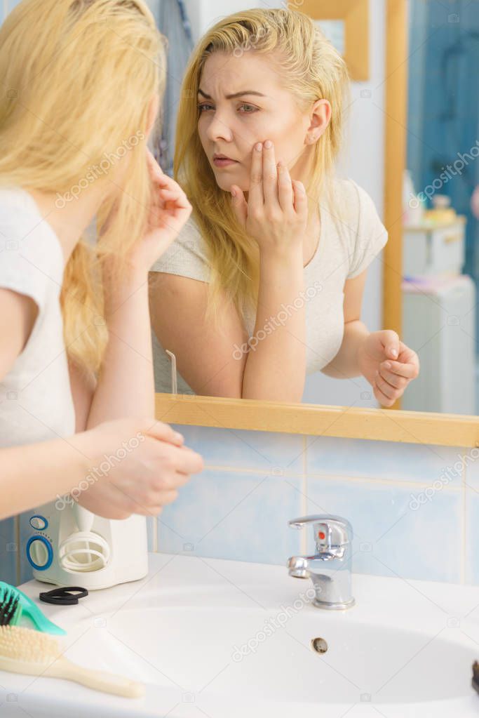 Woman looking at her skin in mirror
