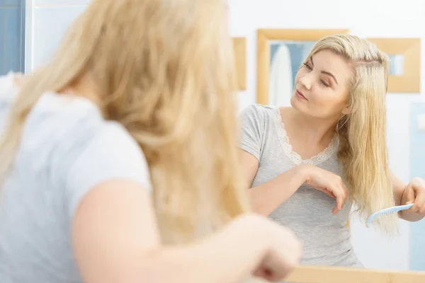 Woman brushing her wet blonde hair