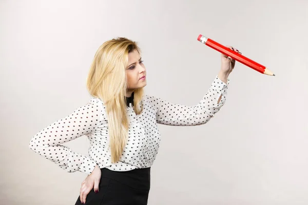 Positive woman holds big pencil in hand — Stock Photo, Image