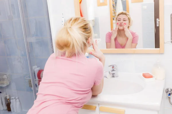 Щаслива жінка миє обличчя під раковиною — стокове фото