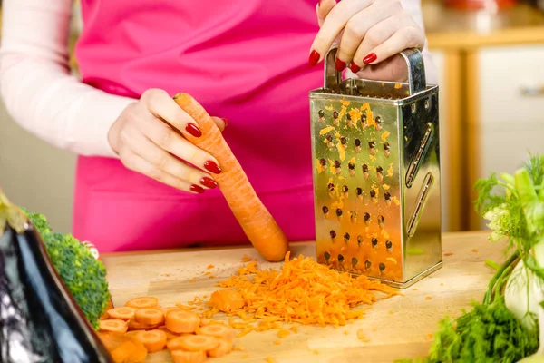 Женская решетка для моркови на металлической терке — стоковое фото