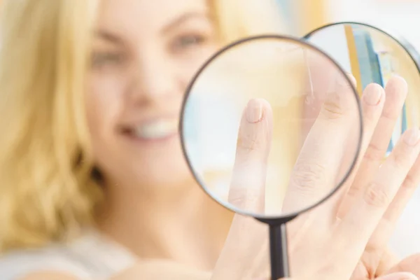 Mujer usando lupa en las uñas — Foto de Stock