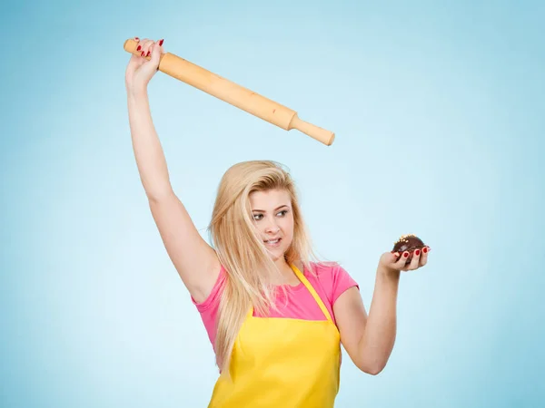 Mujer sosteniendo cupcake y rodillo usando delantal —  Fotos de Stock