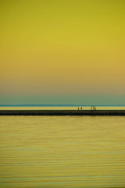 Paesaggio marino con persone che camminano sul frangiflutti — Foto Stock