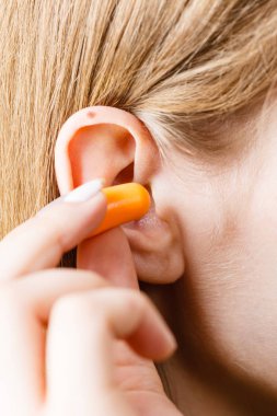 Kulak tıkacı koyarak kadın