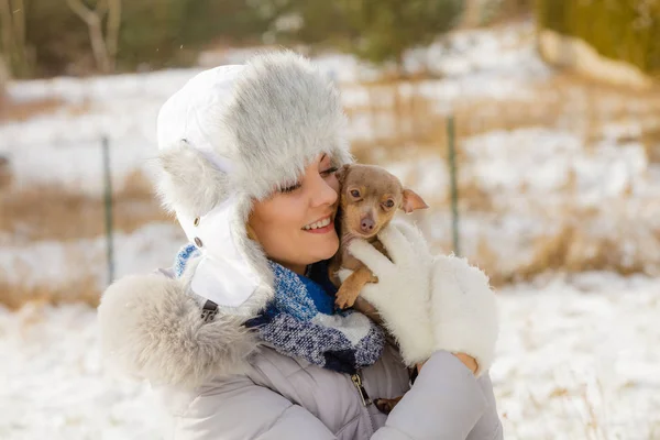 Mulher brincando com cão durante o inverno — Fotografia de Stock