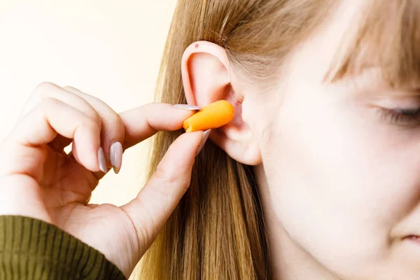 Woman putting earplugs Royalty Free Stock Images