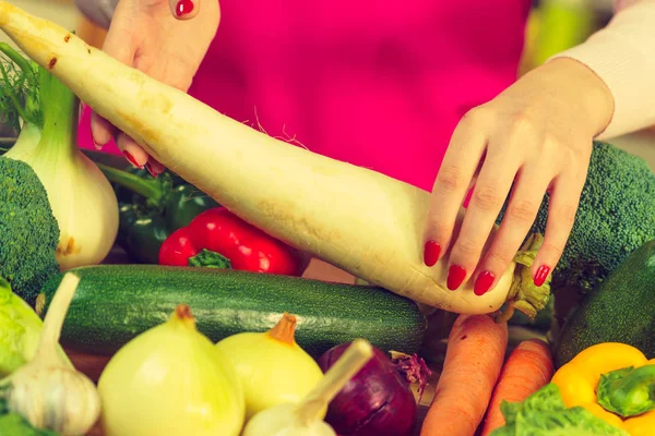 Vrouw hand bedrijf wit raddish — Stockfoto