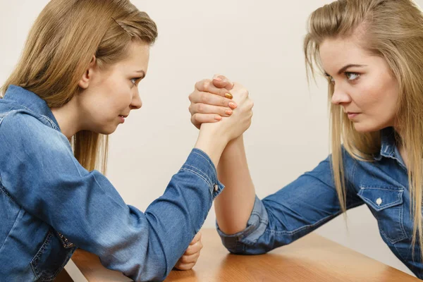 Two women having arm wrestling fight