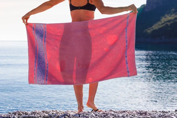 Kobieta na plaży obejmujących biodra z ręcznikiem — Zdjęcie stockowe