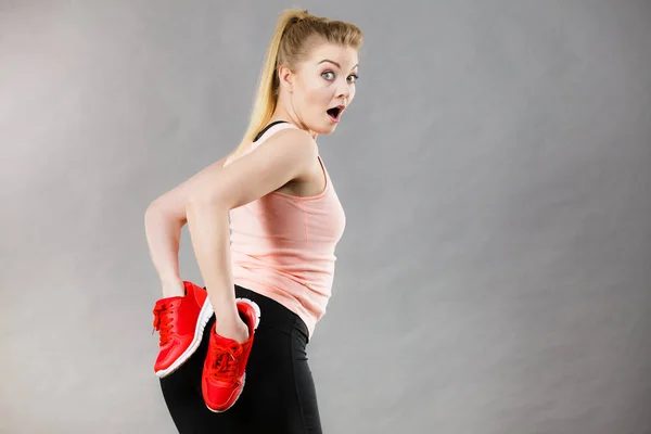 Happy woman presenting sportswear trainers shoes — Stock Photo, Image