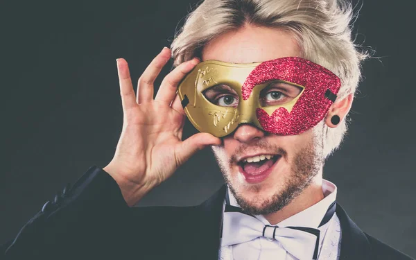 Ung man i carnival mask på mörk — Stockfoto