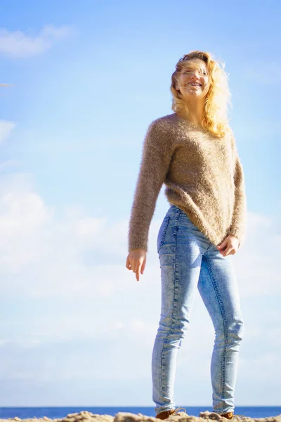 Mujer en suéter caminando en la playa — Foto de Stock